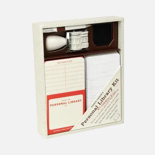 Personal library kit with cards, stamps, and a notebook, ideal for organizing and lending books.