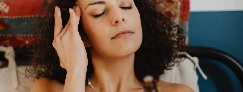 Woman applying clean skincare with eyes closed, illustrating how beauty products affect stress, hormones, and the nervous system.