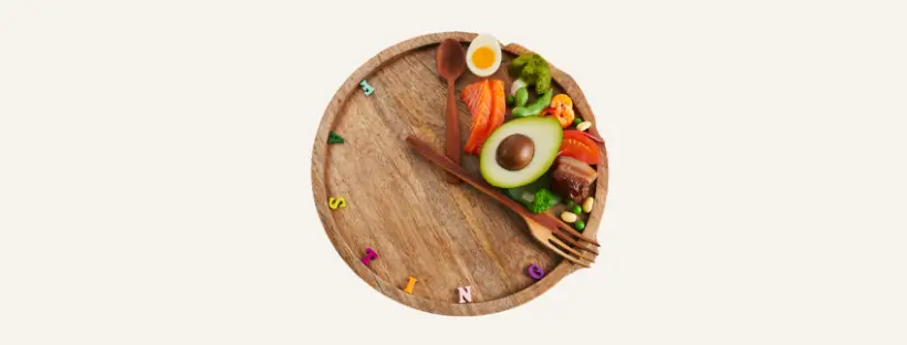 Clock-shaped wooden plate with nutrient-dense whole foods, symbolizing time-restricted eating and balanced insulin support after 40.