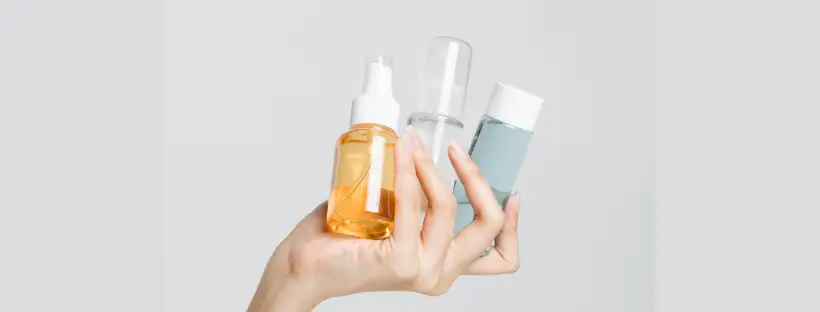 Hand holding clean organic skincare bottles symbolizing consumer power to demand non-toxic beauty products.