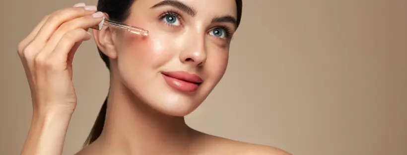 Woman applying clean non-toxic serum with dropper for sensitive skin care.